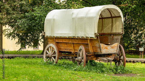 a cowboy wagon without a horse stands on the grass © Mihail