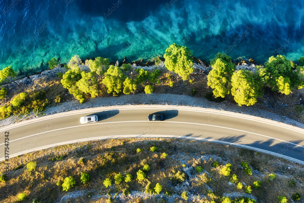 View of the road along the coast from the drone. Travel by car in summer time. The sea coast and the road. The coast of Europe.