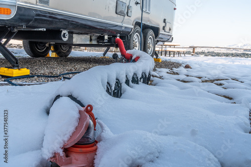 Photography A trailer, RV, sewage drain hose covered with fresh snow connected to the city hookup, dump