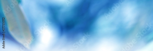 Light blue background. Leaf blurred. The bokeh circle from the leaves with light shining through. Abstract background.