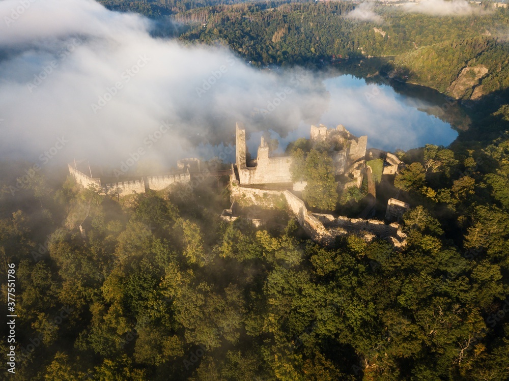Cornstein Medieval castle in South Moravia region during amazing sunrise, Czech republic, Europe. Aerial drone view. Summer or autumn time.
Misty and sunny atmosphere.