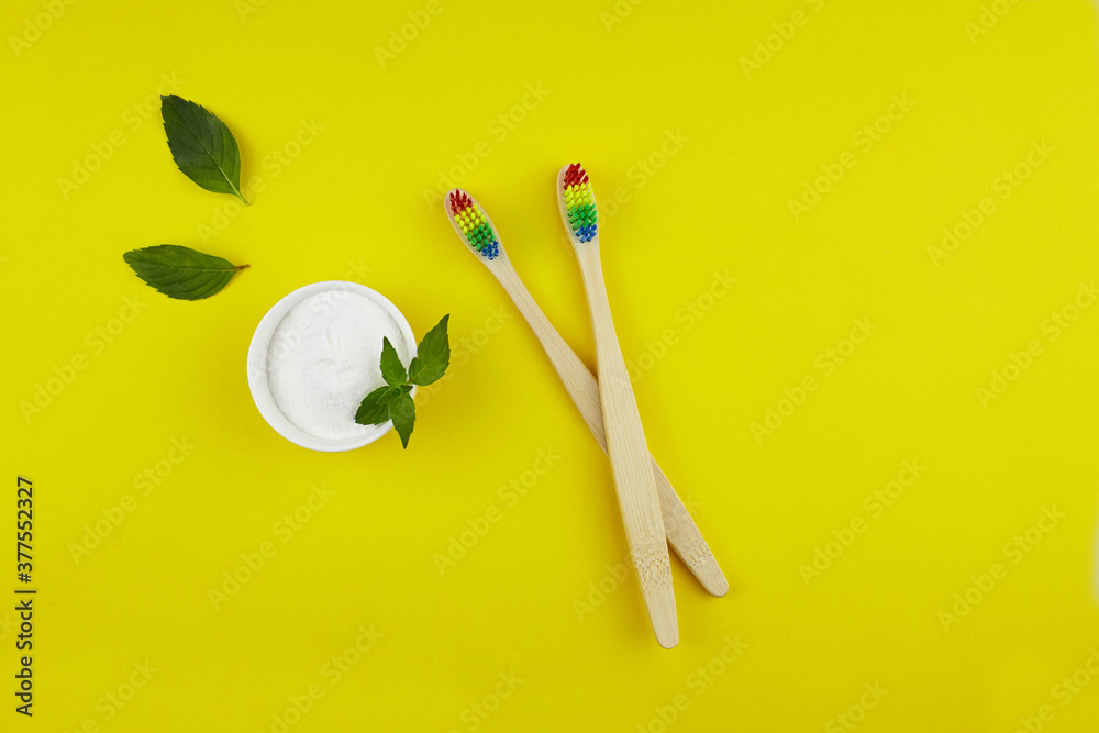 Bamboo rainbow toothbrushes, tooth cleaning powder and mint leaves. No plastic, Zero waste concept. Top view. Bamboo rainbow toothbrushes, tooth cleaning powder and mint leaves. No plastic, Zero waste concept. Top view.