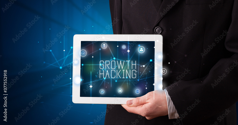 Young business person working on tablet and shows the digital sign: GROWTH HACKING Young business person working on tablet and shows the digital sign: GROWTH HACKING
