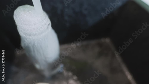 Clean water goes to waste while overfilling bottle