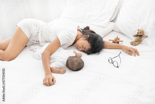 Fotografie Tired Exhausted Mother Sleeping Sleep With Baby On White Bed