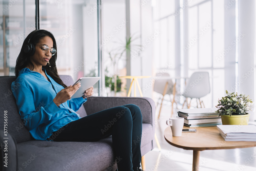 Presentable ethnic woman with tablet resting in office Presentable ethnic woman with tablet resting in office