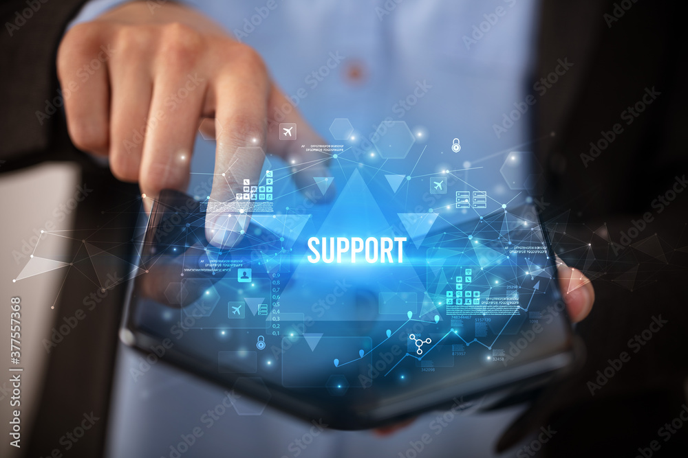 Businessman holding a foldable smartphone with SUPPORT inscription, business concept Businessman holding a foldable smartphone with SUPPORT inscription, business concept