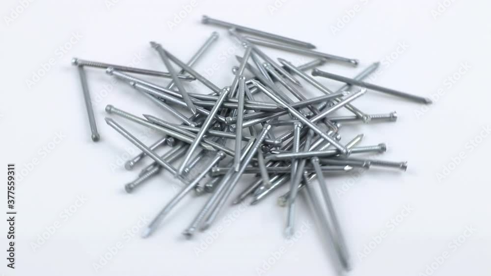 Close-up pile of grey metal nails rotating on white background, side view. Stainless fastener used in construction
Close-up pile of grey metal nails rotating on white background, side view. Stainless fastener used in construction