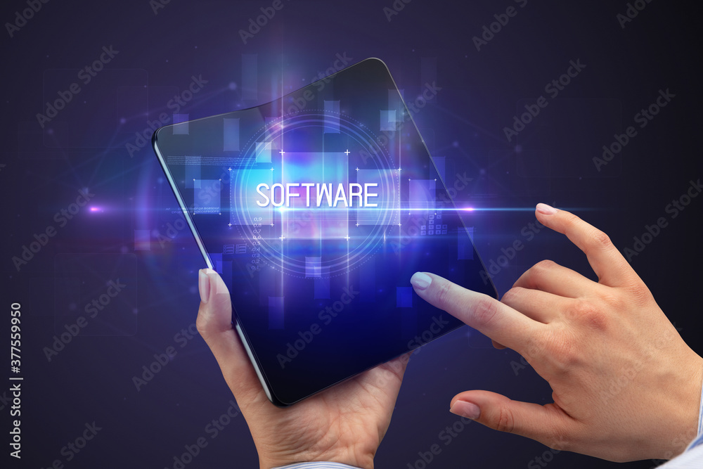 Businessman holding a foldable smartphone with SOFTWARE inscription, new technology concept Businessman holding a foldable smartphone with SOFTWARE inscription, new technology concept