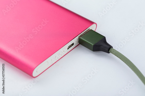 Power bank for charging mobile devices. Pink smart phone charger with power bank. battery bank.