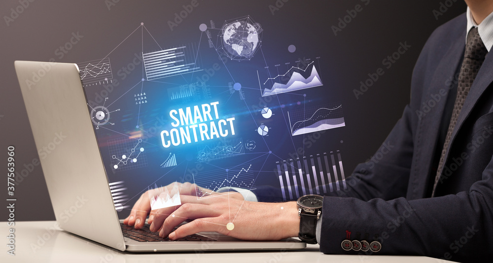 Businessman working on laptop with SMART CONTRACT inscription, new business concept Businessman working on laptop with SMART CONTRACT inscription, new business concept