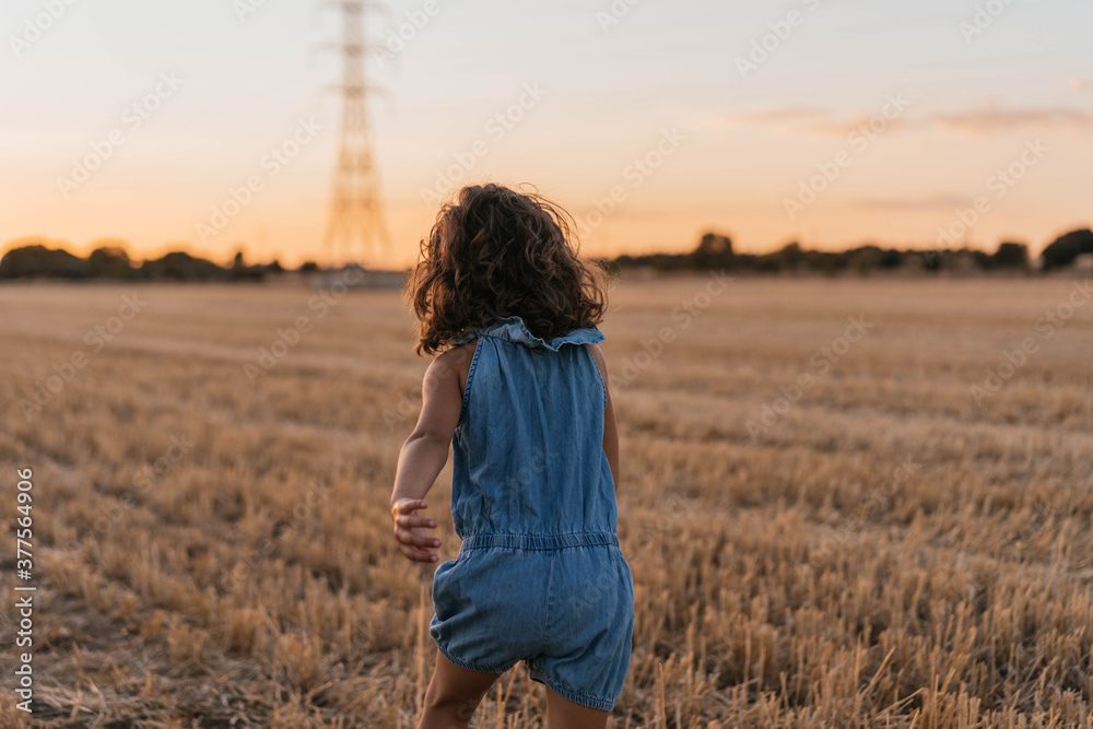 Young girl running on her back while playing in the field Young girl running on her back while playing in the field