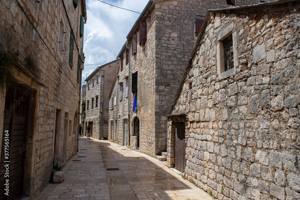 Stari Grad/ Croatia-August 7th, 2020: Traditional stone houses in narrow street, native to dalmatian region of Croatia, famous tourist attraction for sightseeing