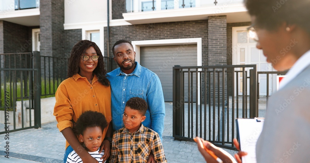 Happy African American family with two small kids buying house at