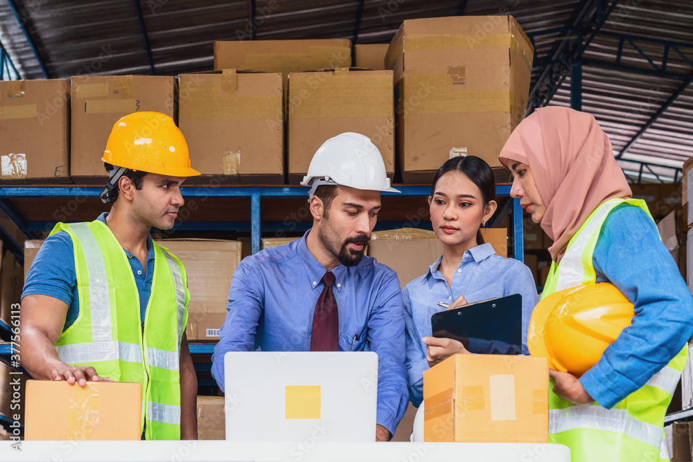 Group of Diversity warehouse worker meeting and brainstorming together in local warehouse, muslim with Hijab, indian, white caucasian and asian people wearing safety clothes in export industry concept Group of Diversity warehouse worker meeting and brainstorming together in local warehouse, muslim with Hijab, indian, white caucasian and asian people wearing safety clothes in export industry concept