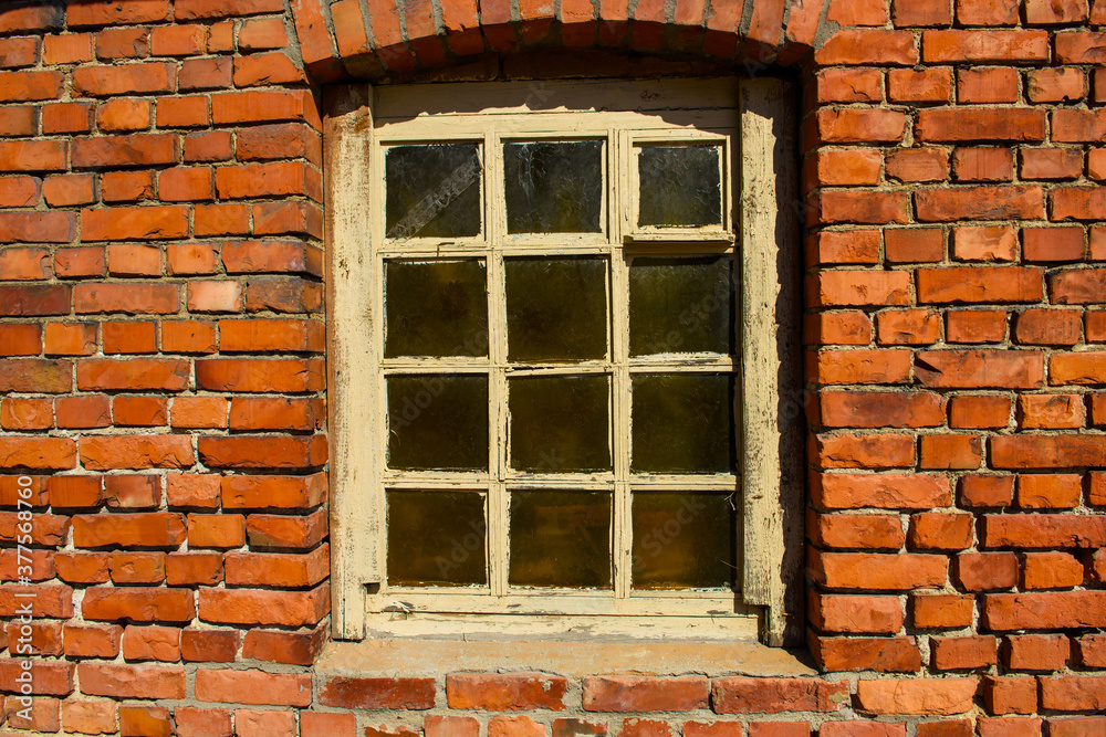Background of an Old red brick wall and an ancient window. Destruction and preservation of historical buildings.