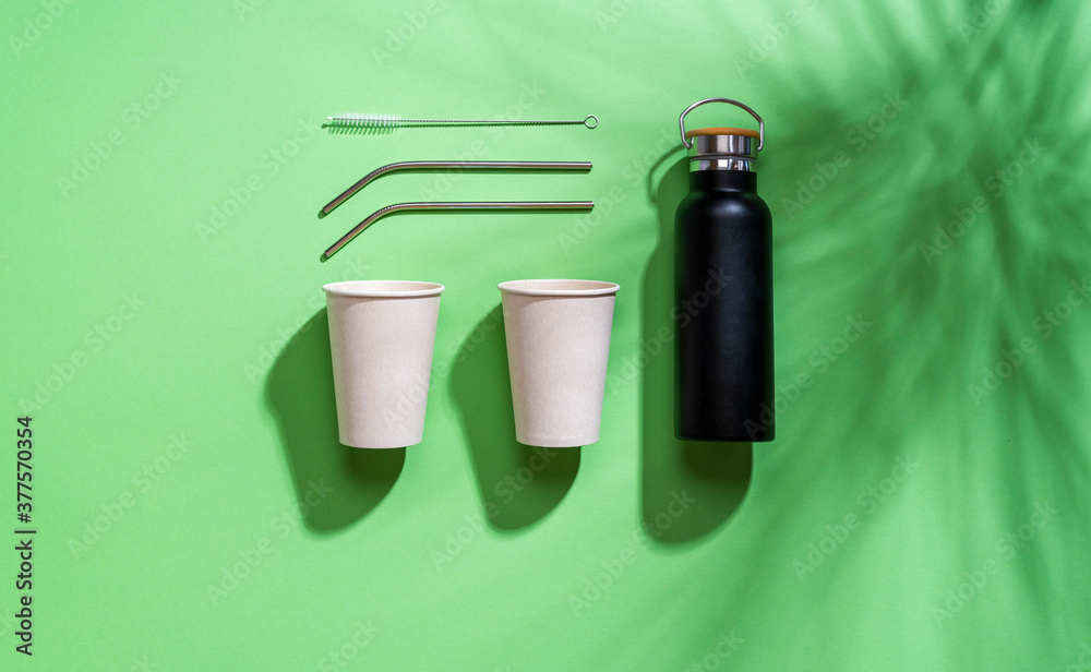 Plastic-free objects flat lay. Reusable drinking containers isolated on green background Plastic-free objects flat lay. Reusable drinking containers isolated on green background