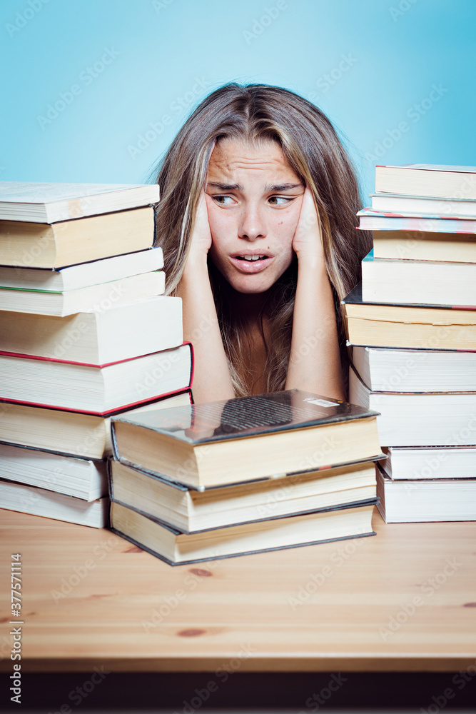 Young pretty student overwhelmed with books Young pretty student overwhelmed with books