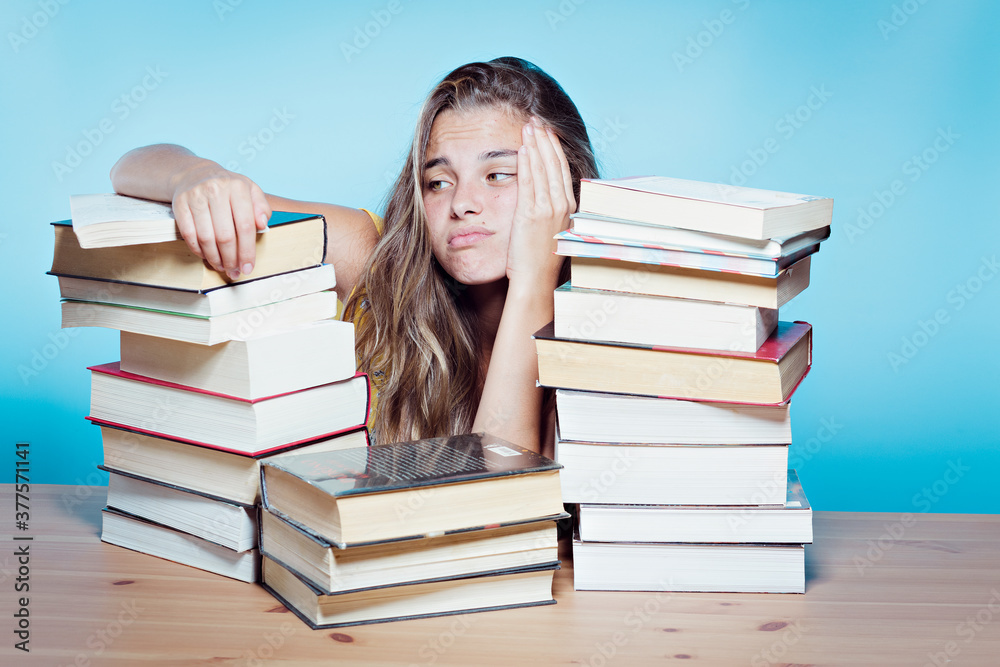Young pretty student overwhelmed with books Young pretty student overwhelmed with books