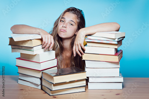 Young pretty student overwhelmed with books
