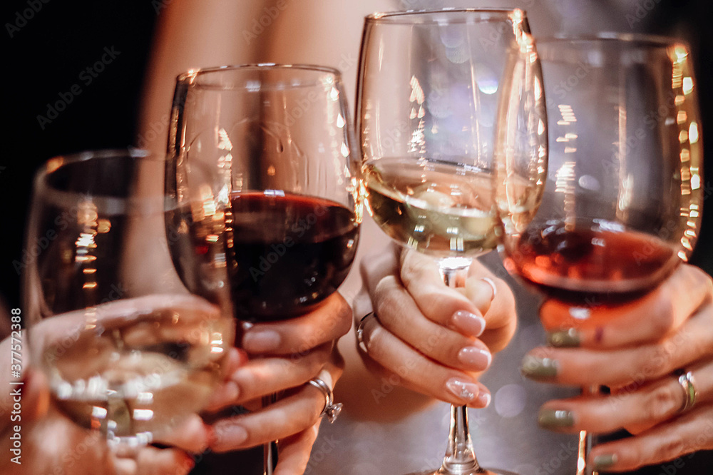 Hands of group of friends toast with red and white wine glasses. Party and celebration concept Hands of group of friends toast with red and white wine glasses. Party and celebration concept