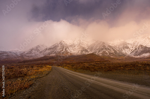 Mountain road through snowy peaks at early morning in Alaska