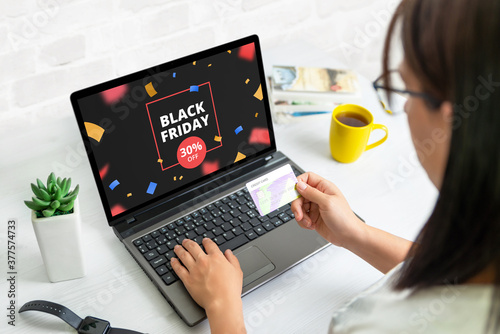 Obraz na plátně Black friday shopping online concept with discount banner on laptop display