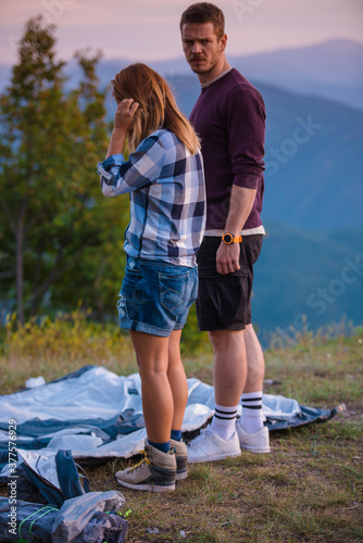 Young couple oppening the tent for bonfire sunset setting photo