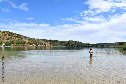 Chubby girl entering the waters of the Ruidera lagoons.