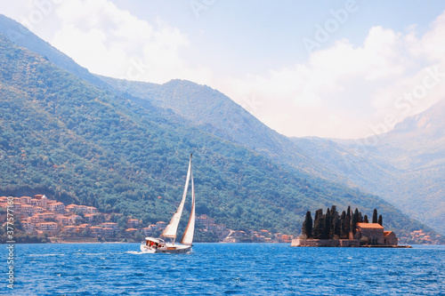 Beautiful Mediterranean landscape. Montenegro. Sailboat sails in the waters of the Bay of Kotor near the Island of St. George. Color toning. Travel concept photo