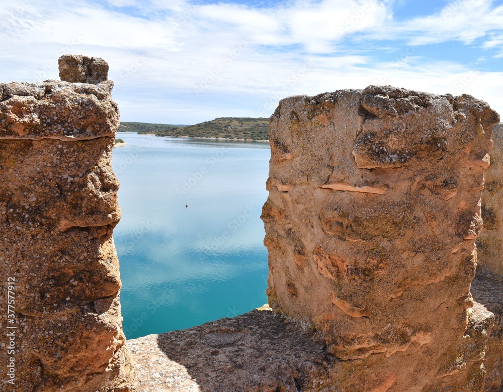 Waters of the Peñarroya reservoir seen through the castle battlements.