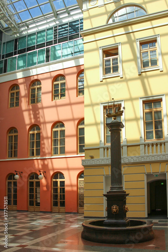statue of boat. Beautiful big Glass roof, red and yellow building with large windows in sunlight 