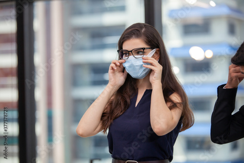 businesswoman with face mask working in the office. Pensive female entrepreneur with face mask working in the office.