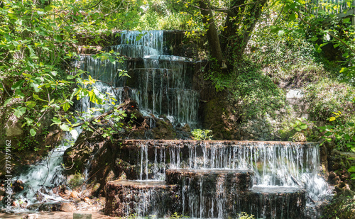 waterfalls cascade flowing in forest and sun light at a beautiful stream water