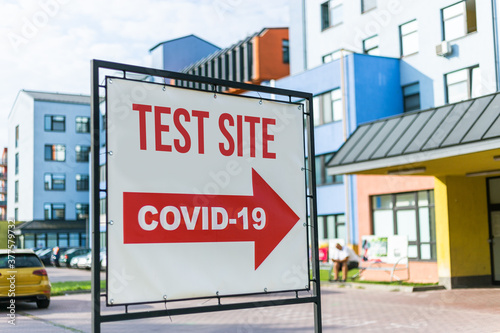 Coronavirus test site sign and arrow to hospital