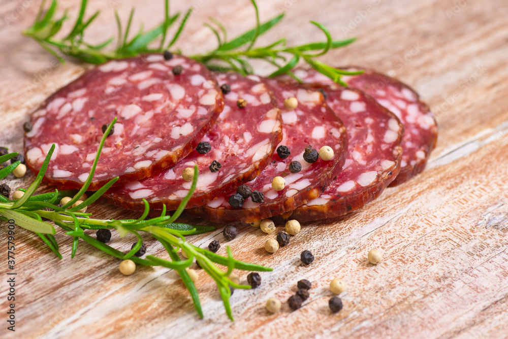 smoked salami on wooden table with rosemary