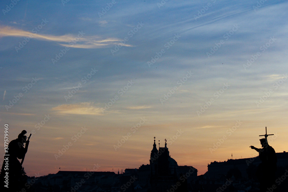 Silhouette of Prague city with colorful sky and sculptures
