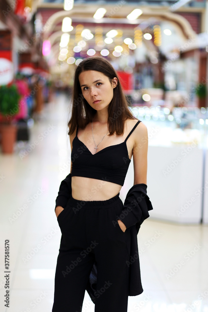 young brunette in black clothes in the mall