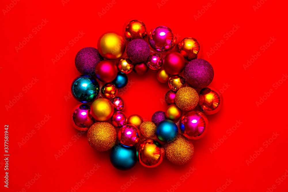 Christmas colorful wreath handmade from christmas balls on a red background. New Year's interior decoration Christmas colorful wreath handmade from christmas balls on a red background. New Year's interior decoration