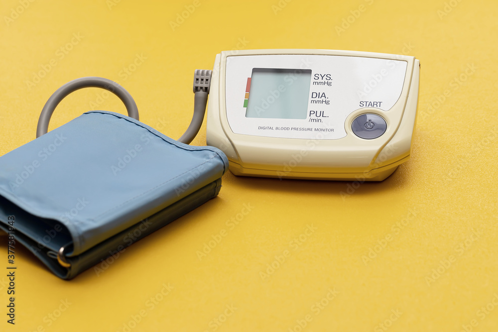 modern medical electronic tonometer on a bright yellow background.