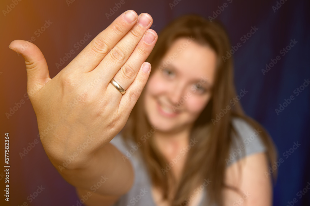 Obraz premium Beautiful young woman showing hand wearing wedding alliance ring