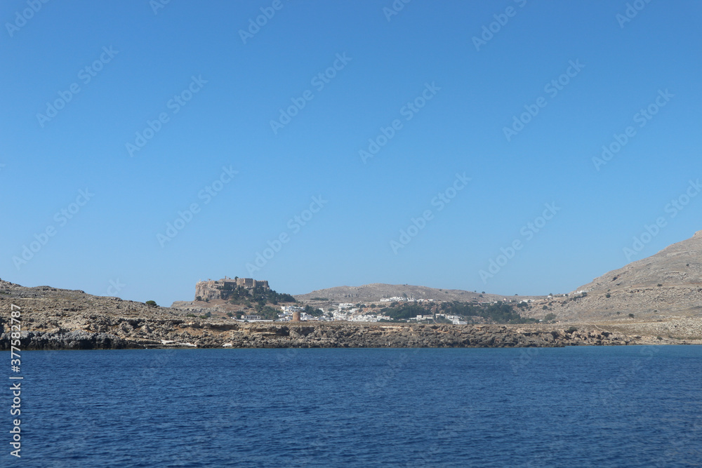 View of Fort from the Ocean. Still Waters with Cliffs. Still blue ocean waters with fort in the background distance. Cliff shores