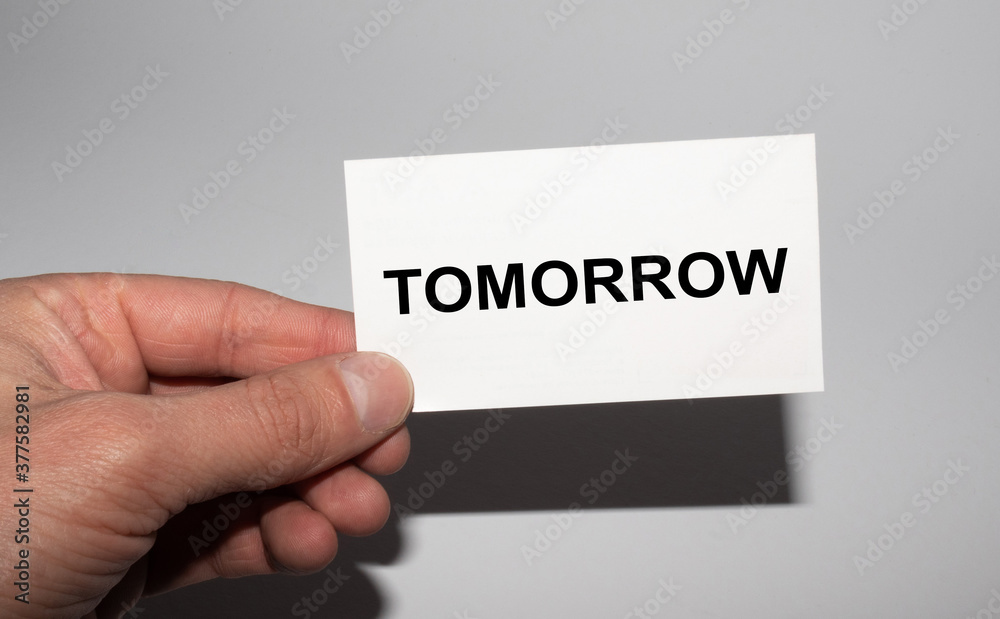 Message on the card TOMORROW, in hands of businessman. Message on the card TOMORROW, in hands of businessman.
