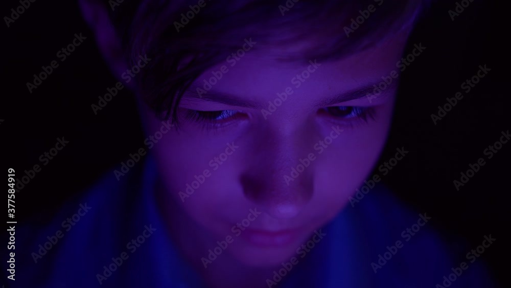 portrait of a boy playing a computer game on the tablet at night portrait of a boy playing a computer game on the tablet at night