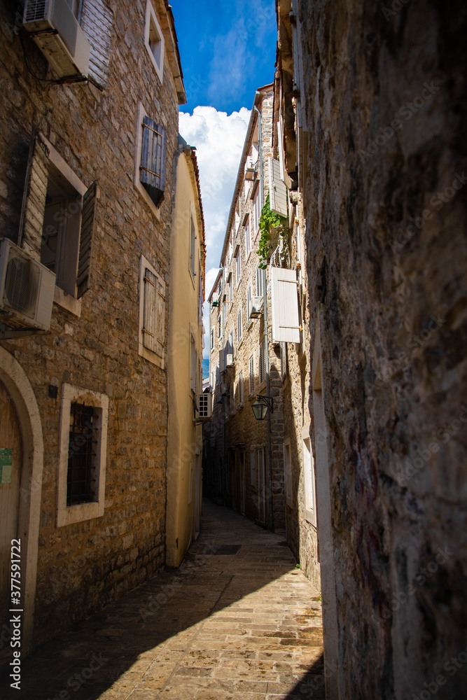 Empty narrow street of the old town of budva in montenegro on a bright sunny day