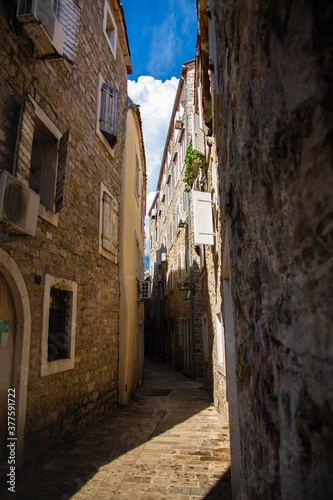 Empty narrow street of the old town of budva in montenegro on a bright sunny day © FellowNeko