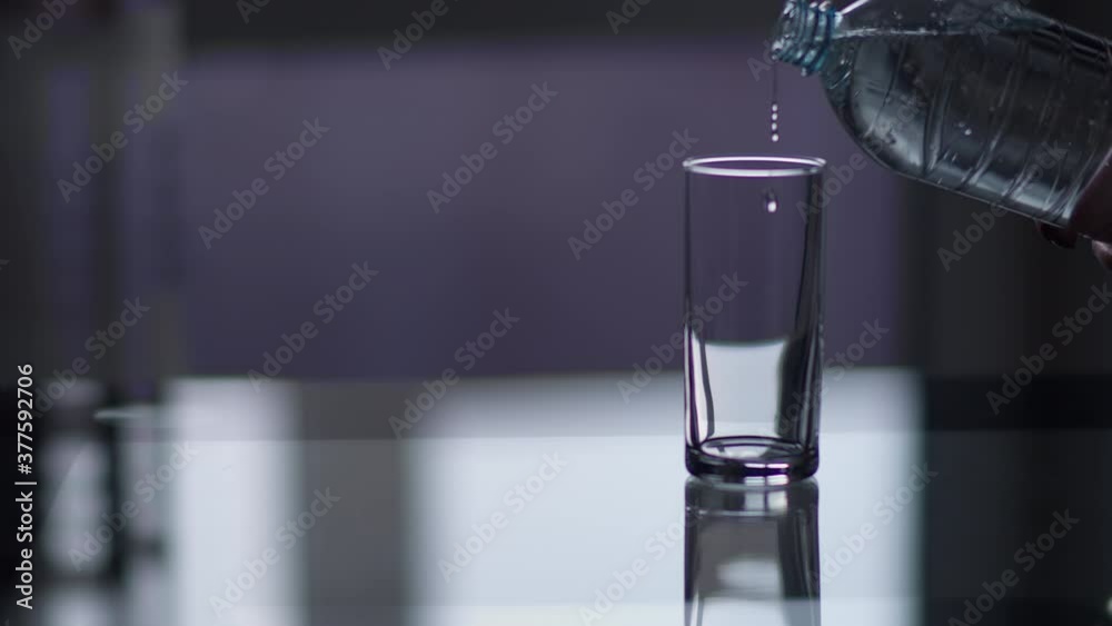 sparkling water pouring from a bottle into a glass in the kitchen sparkling water pouring from a bottle into a glass in the kitchen