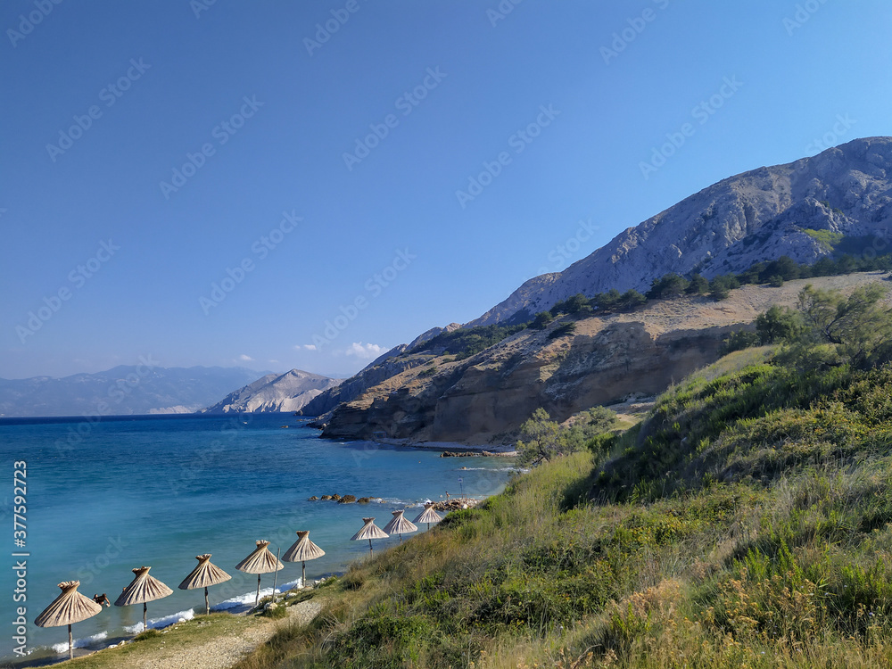 Parasols on main beach in Baska, island Krk, Croatia