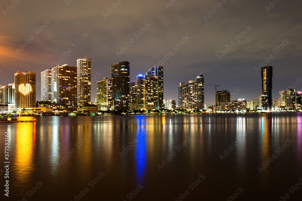 Miami skyline. Miami Florida, sunset panorama with colorful illuminated business and residential buildings and bridge on Biscayne Bay.
