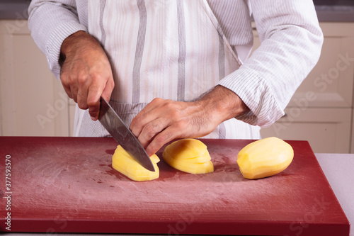 Caucasian male chef slicing potatoes with skill